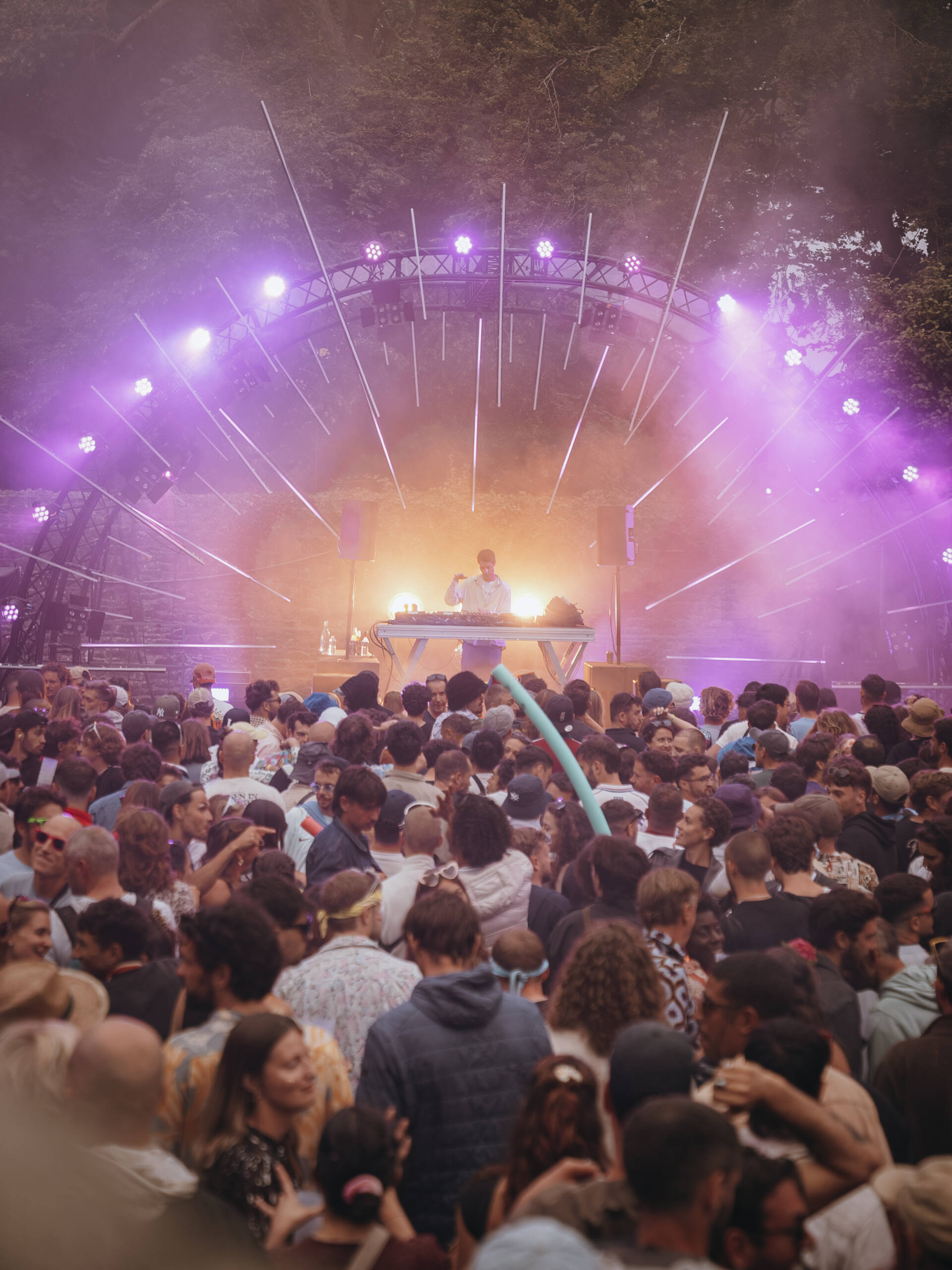 Foule dansant devant la scène du festival Astropolis, sous les lumières violettes