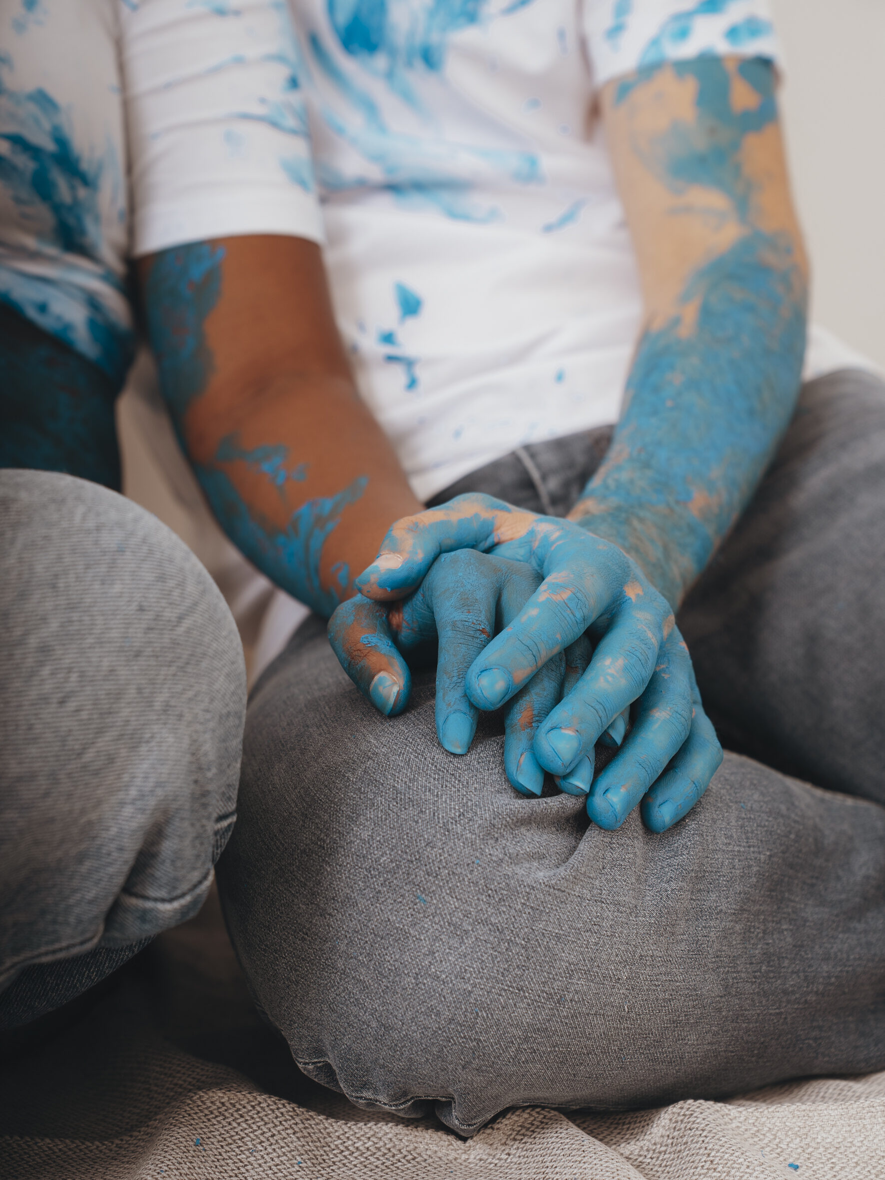 Mains entrelacées couvertes de peinture bleue, séance couple créative