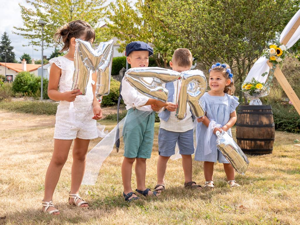 Enfants d’honneur portant des ballons en forme de lettres