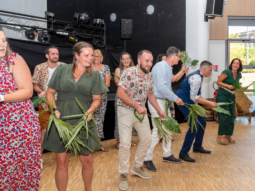 Animation de soirée : invités dansant avec des feuilles de palmier