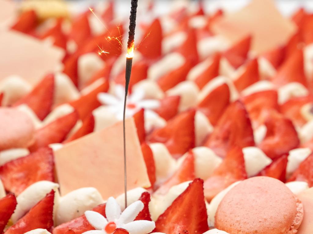 Cierge magique sur un gâteau aux fraises et aux macarons