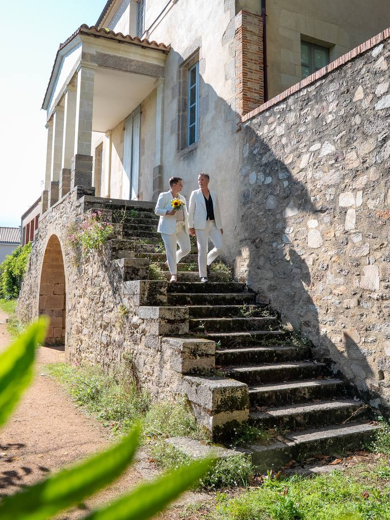 Les mariées descendent le grand escalier de pierre d’une demeure ancienne