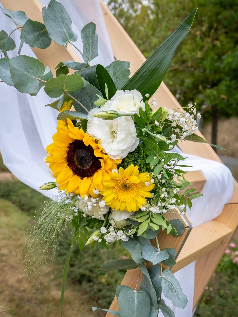 Bouquet de tournesols et de roses blanches sur l’arche de la cérémonie laïque
